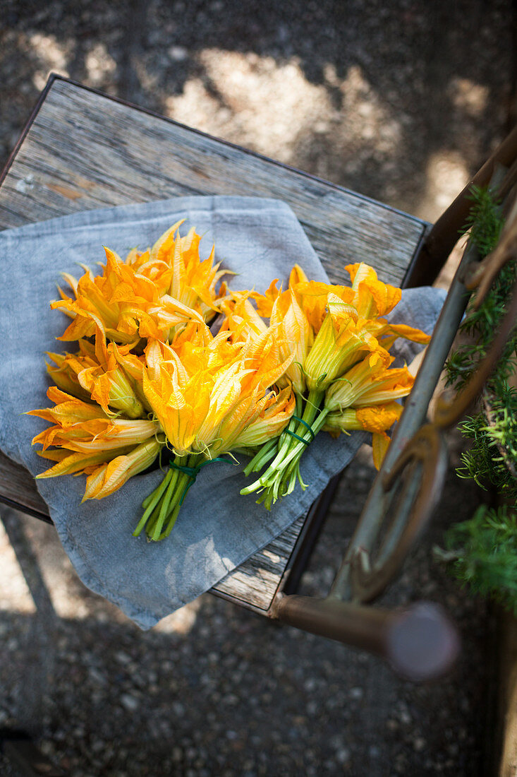 Courgette flowers on a wooden chair