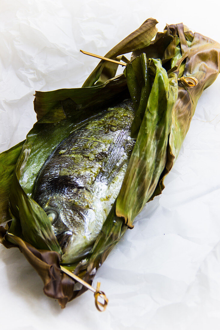 Steamed gilt-head bream in a banana leaf with pesto