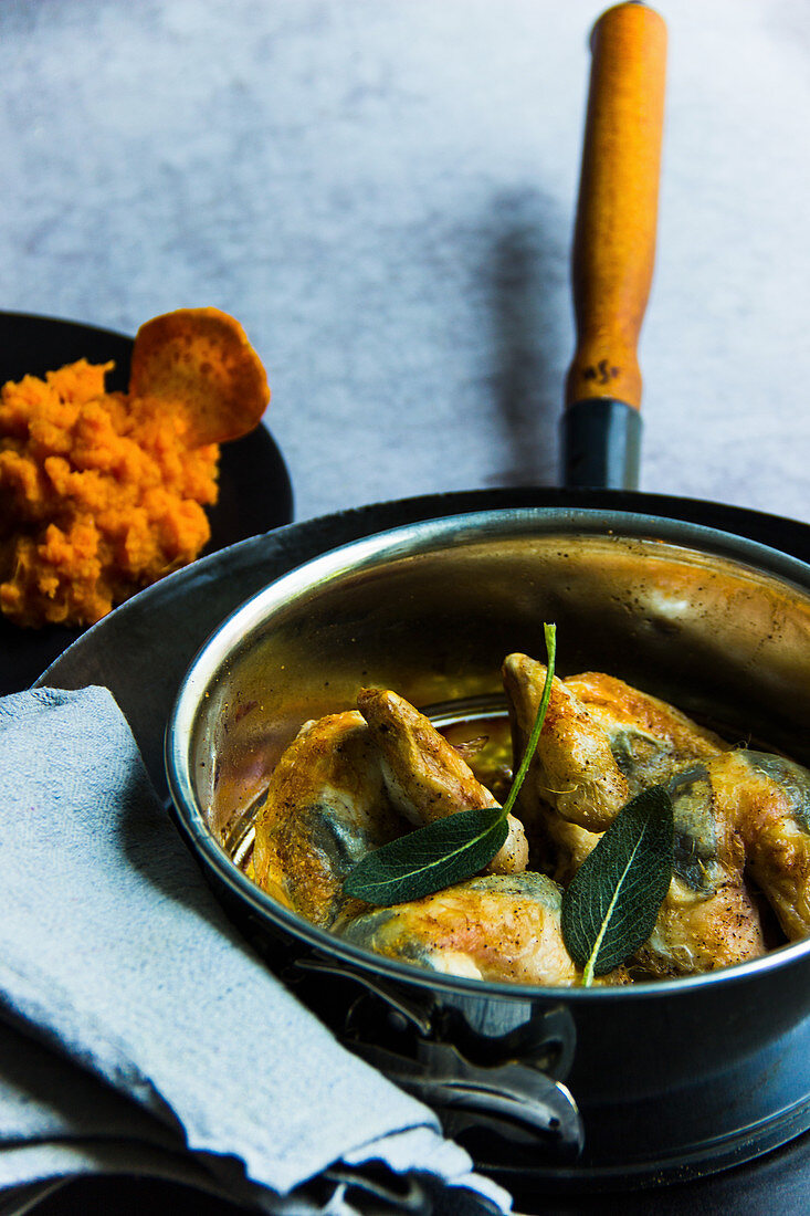Poussin with sage in a pot served with mashed sweet potatoes