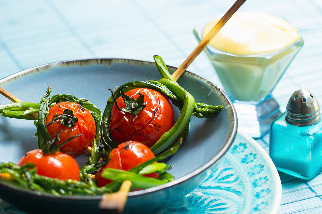 Fingerfood skewers with tomatoes and wild asparagus served with Sauce Hollandaise