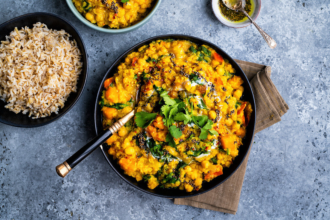 Vegan dal with red lentils, squash, chickpeas and spinach in a bowl with rice (India)