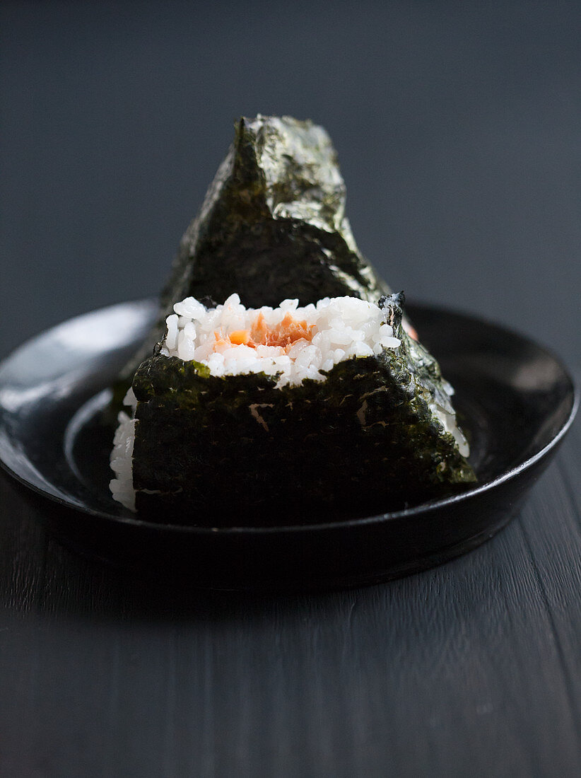 Two onigiri filled with salmon, one bitten (Japan)