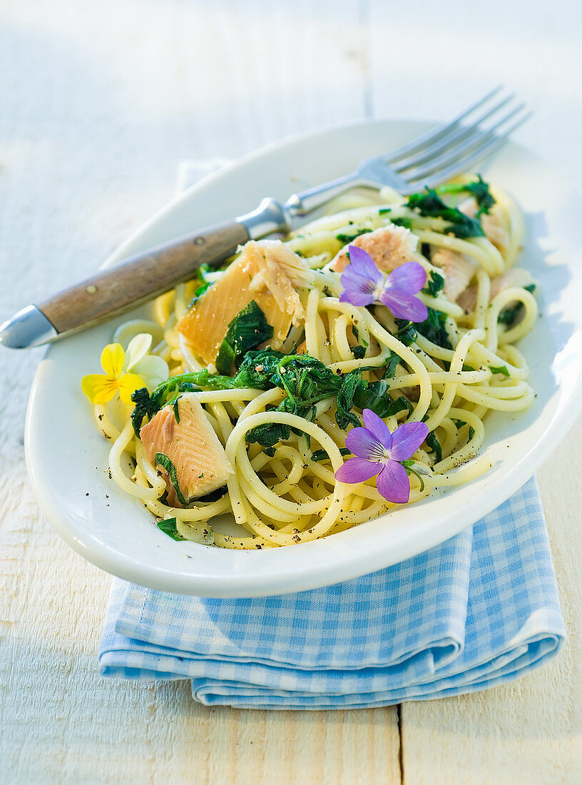 Spaghetti with smoked trout fillets and edible flowers