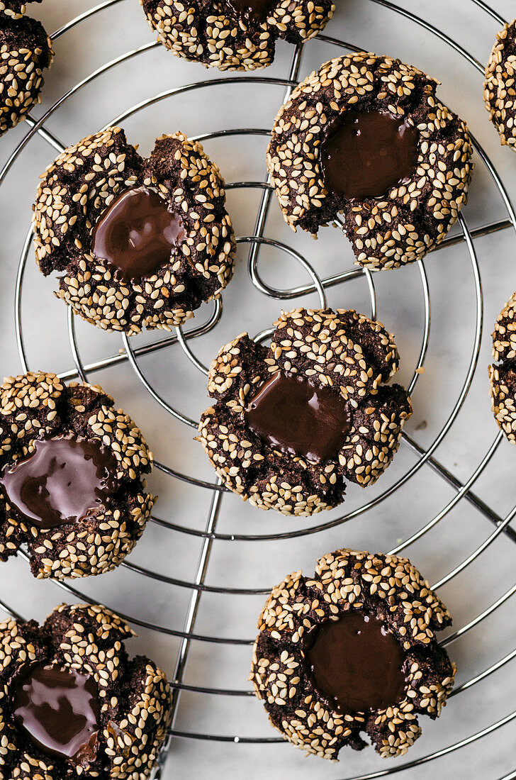 Chocolate thumbprint cookies with tahini on a cooling rack