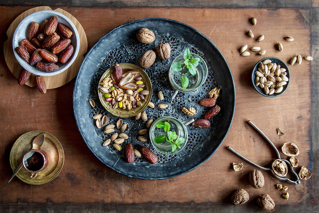 Healthy teatime oriental style with mint tea, dates, walnuts and pistachios