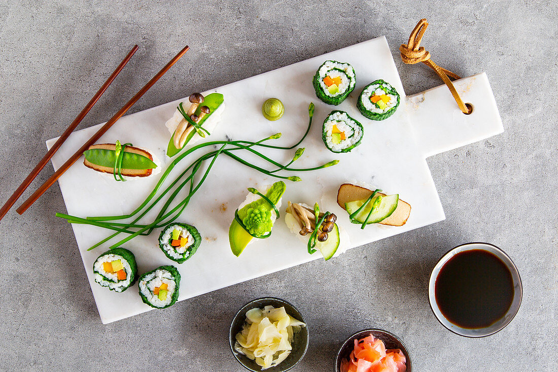 Springlike vegan maki and nigiri sushi with smoked tofu, mushrooms, fresh fruit and vegetables