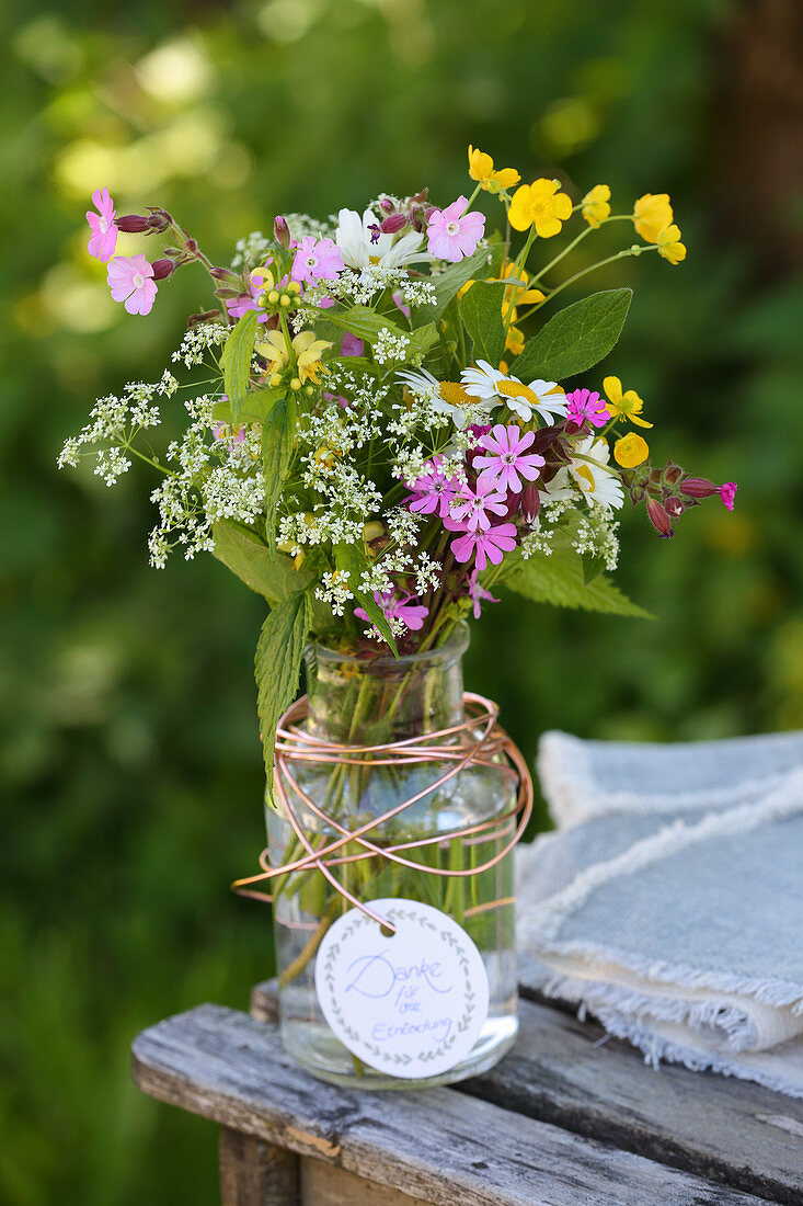 Vase of summer wildflowers with red campion, buttercups, ground elder and ox-eye daisies