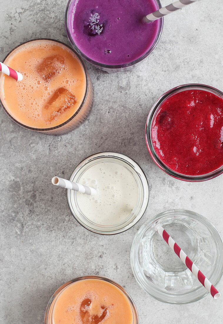 Glasses of smoothies with striped paper straws