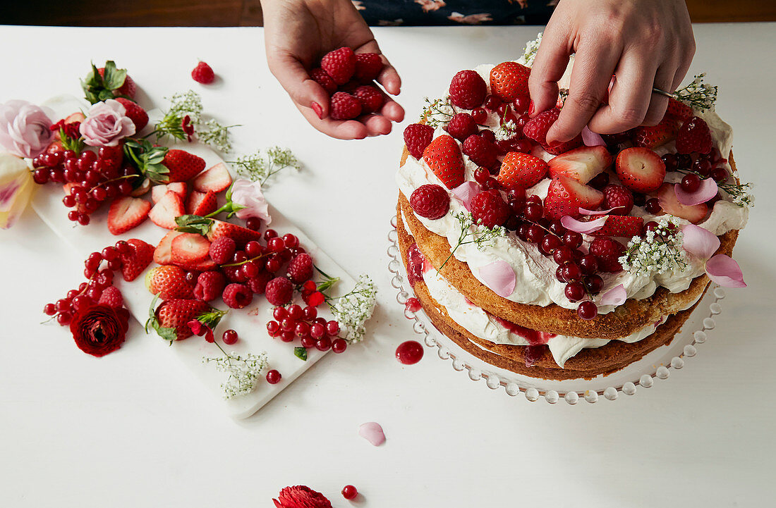 Victoria Sponge Cake mit Beeren und Blüten dekorieren