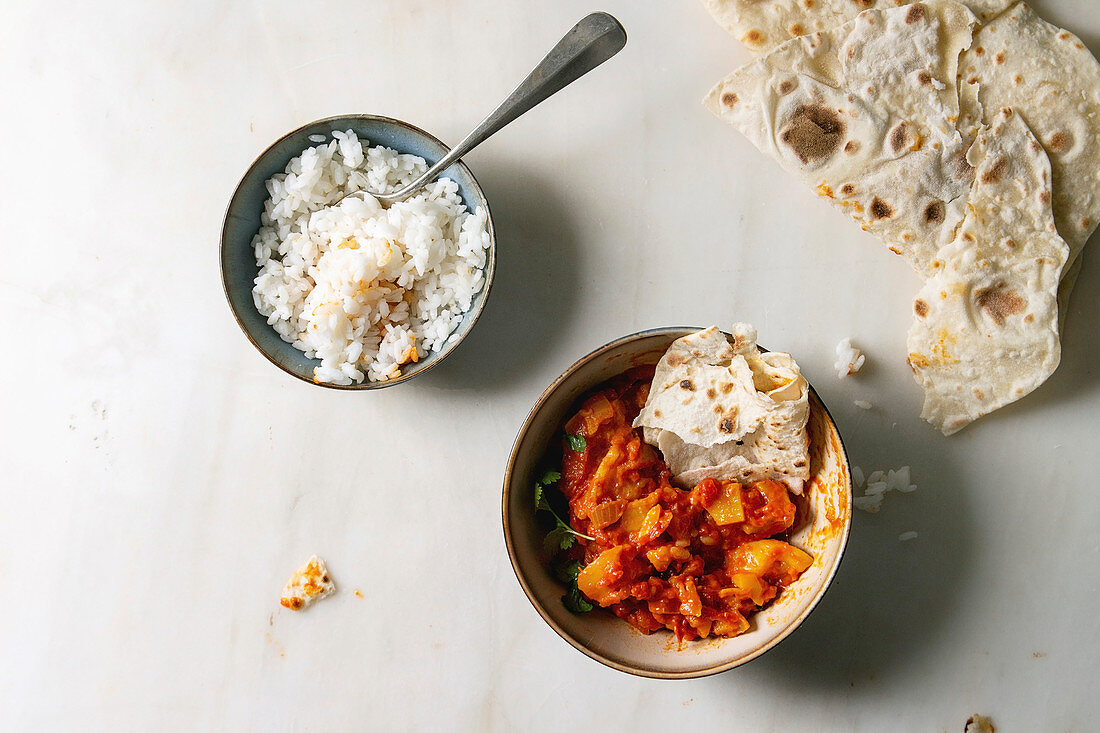 Veganes Jackfrucht-Curry serviert mit Reis und Fladenbrot (Asien)