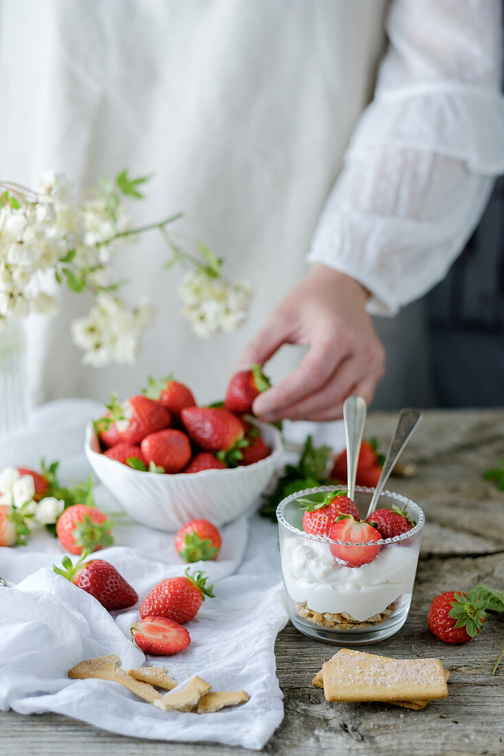 Chef using fresh juicy tasty strawberries while preparing creamy sweet dessert