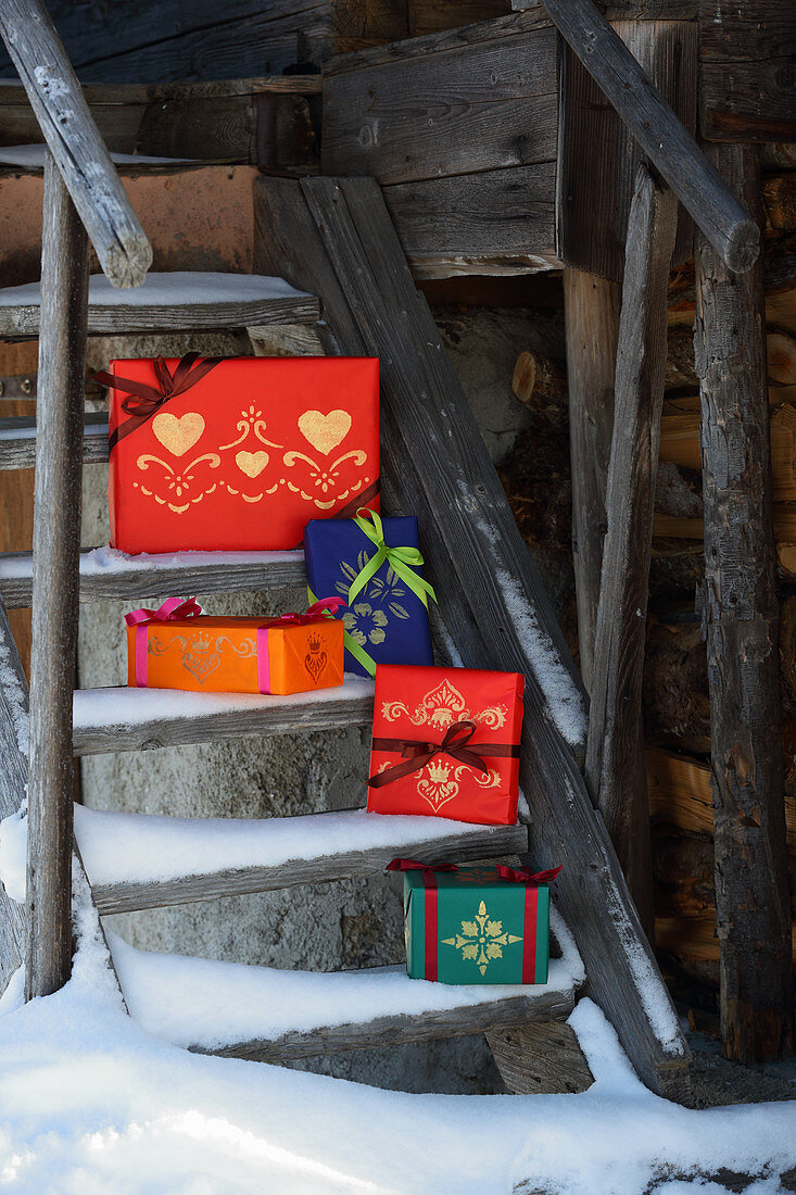 Geschenkpäckchen in farbenfrohem Papier mit Schablonenmustern dekoriert