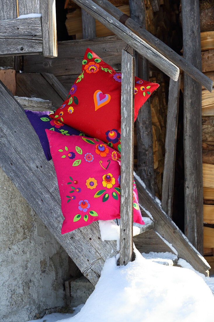 Colourful cushions decorated with ethnic felt flowers and felt hearts
