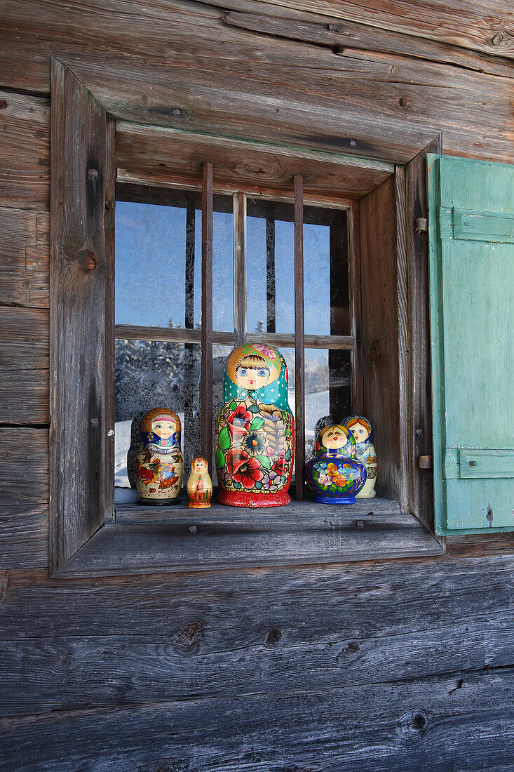 Traditional Russian dolls on windowsill of wooden cabin