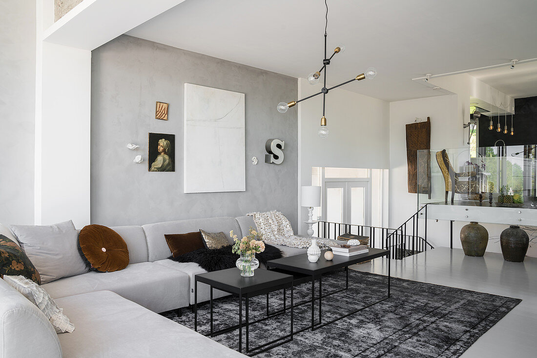 Corner sofa in pale grey designer living area with dining area in background on raised level