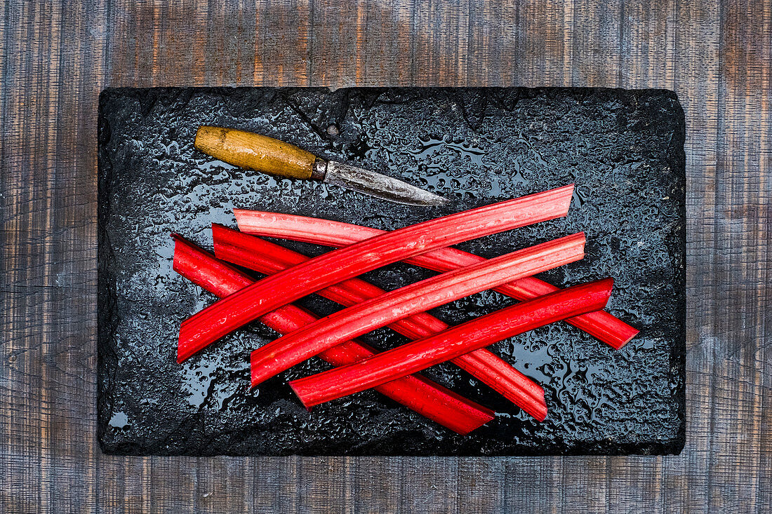 Rhubarb stalks with a vintage knife on a stove plate