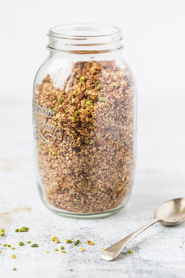 A jar of breakfast granola with pistachios