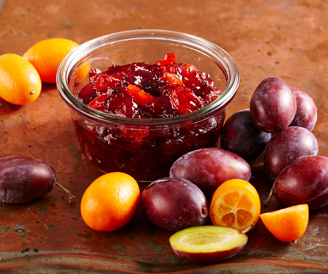 Spicy plum kumquat jam in a mason jar on a copper sheet