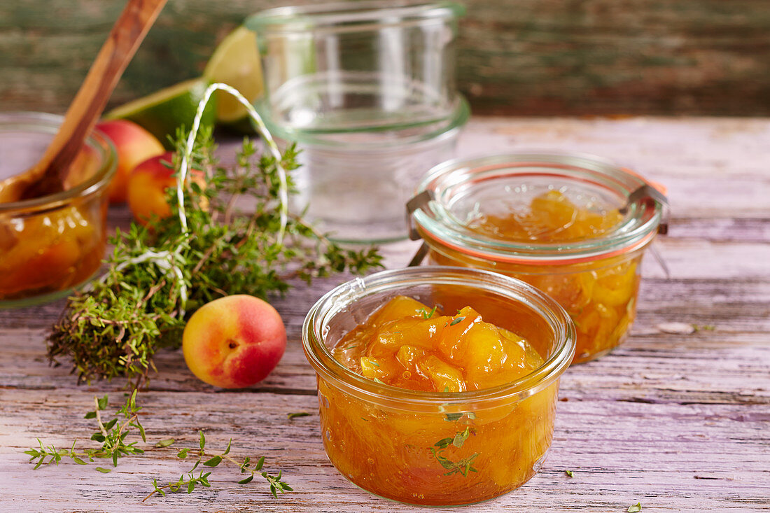 Homemade apricot jam with fresh thyme in a mason jar