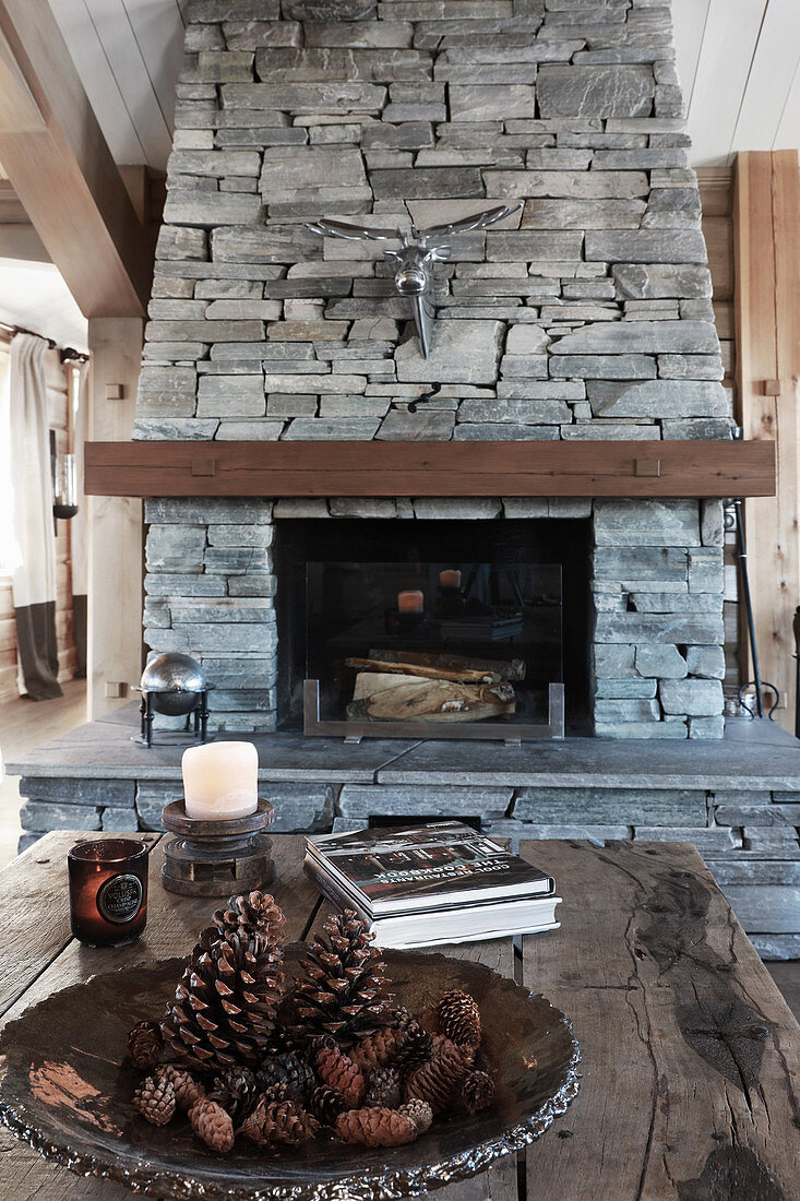 Open fireplace with stone surround in rustic living room
