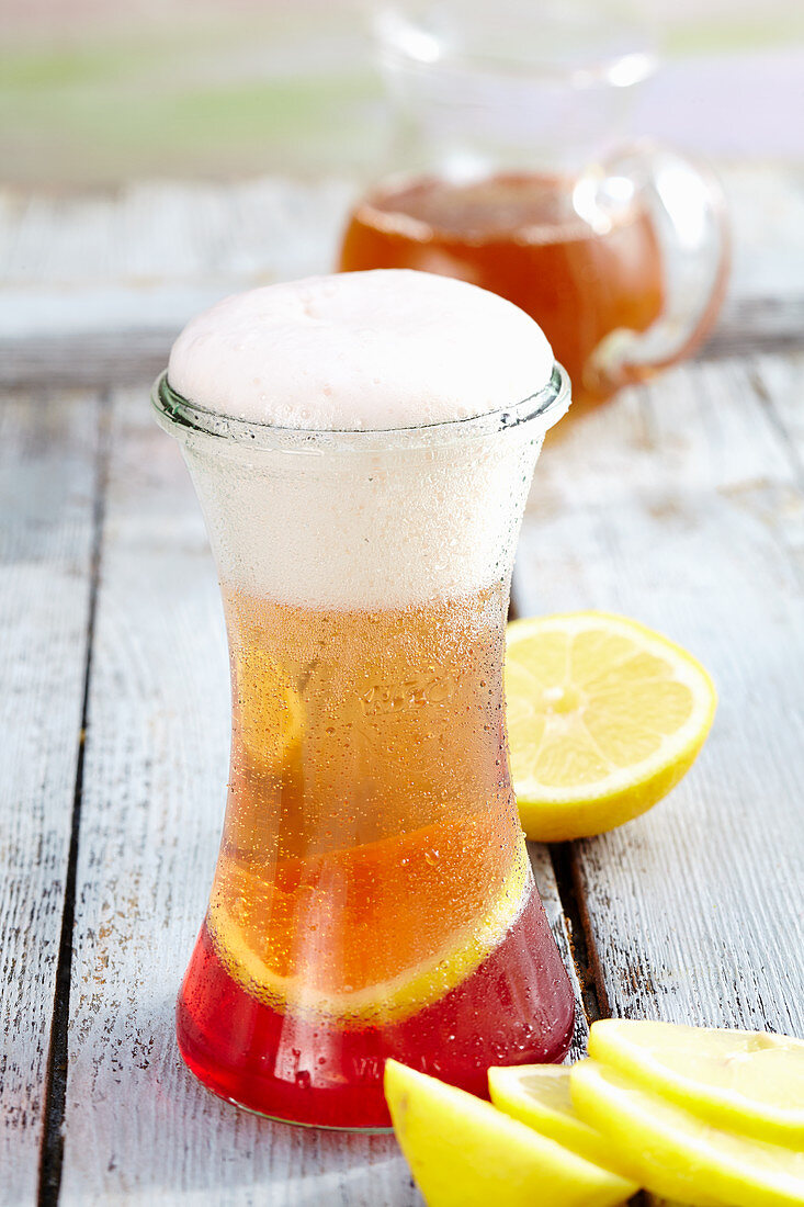 Summery cocktail with light beer, grenadine and apple juice spritzer