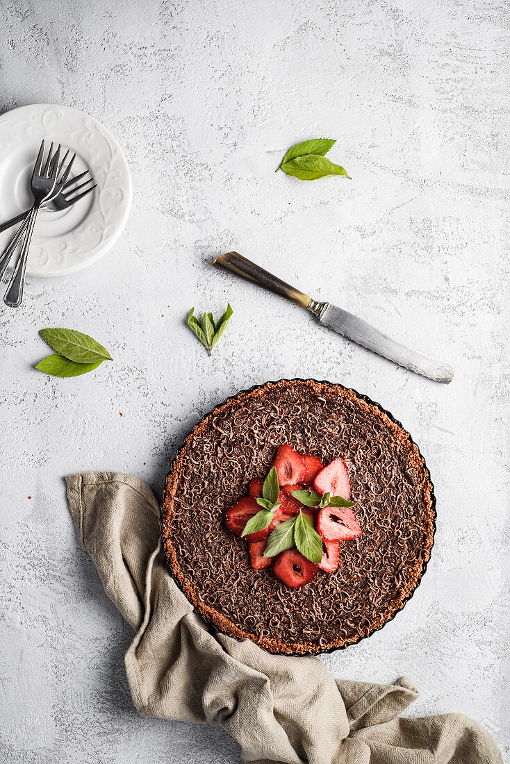 Chocolate tart with strawberries and mint leaves