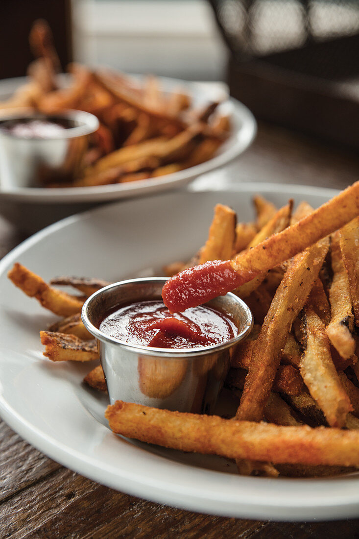 Fries dipped in homemade ketchup