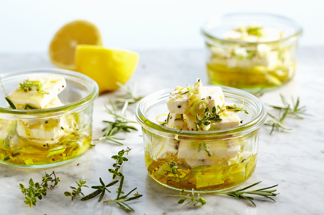 Pickled feta cheese in olive oil with garlic, spring onions, thyme, rosemary and lemon pepper