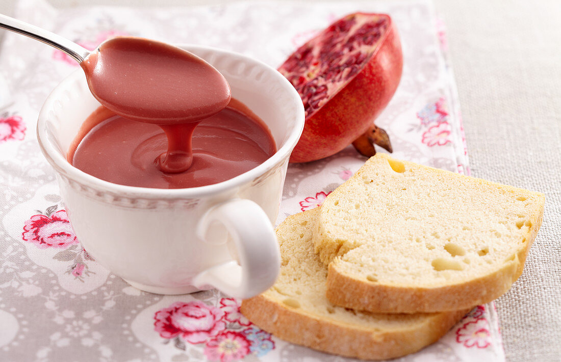 A cup of pomegranate curd with a spoon