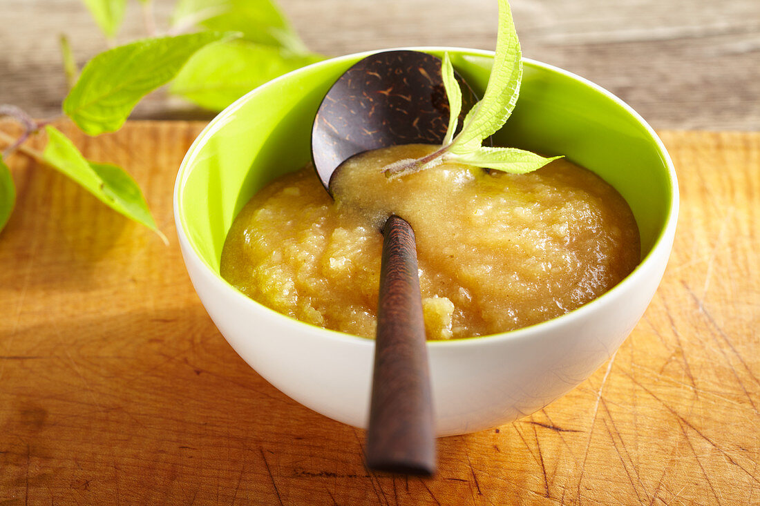Coconut and pineapple jam in a bowl with a wooden spoon