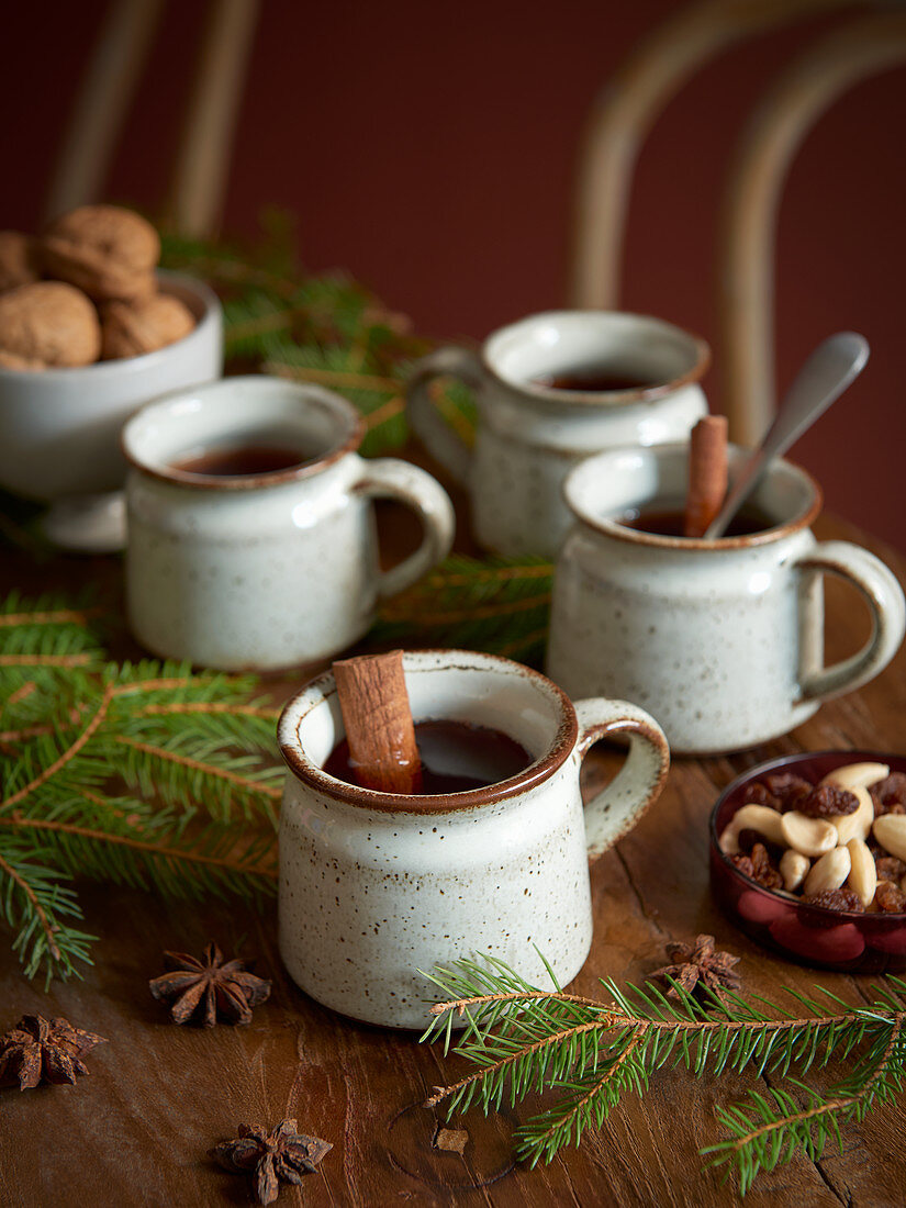 Rustic cups of mulled wine with cinnamon sticks