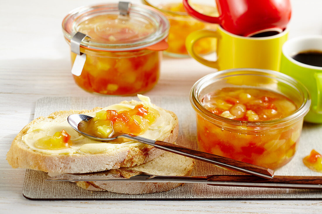 Pineapple and papaya jam with banana in jars and on buttered bread