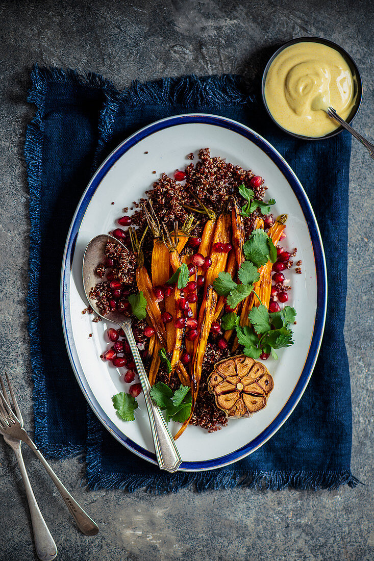 Roasted carrots with garlic, quinoa, pomegranate and coriander with yoghurt and tahini dressing