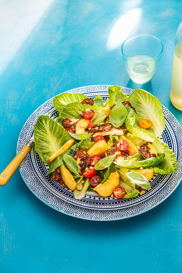 Summer salad with griled hallumi, nectarines, pine nuts and lettuce leaves