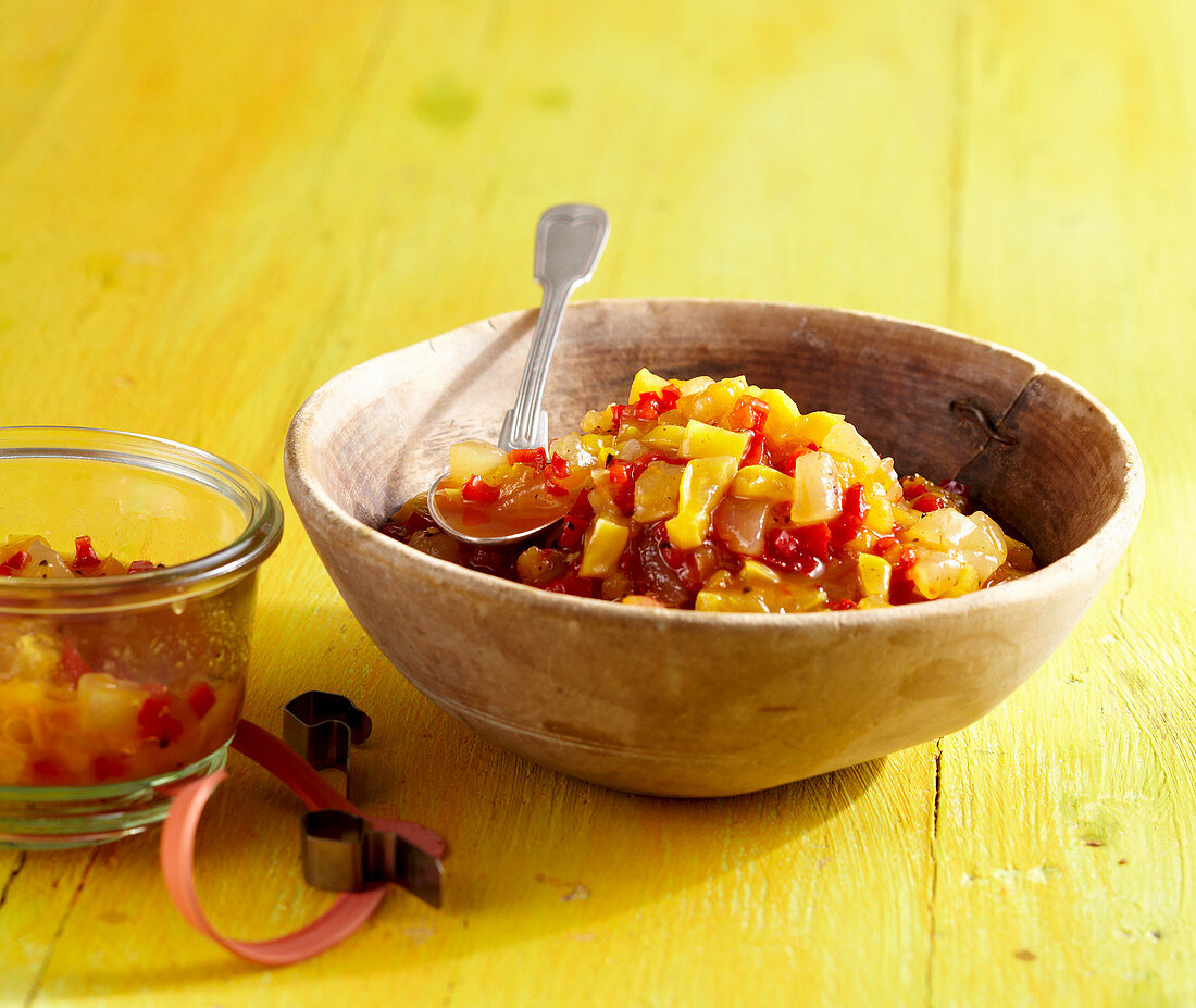 Melon chutney with star fruit, pepper, allspice and vinegar in a wooden bowl