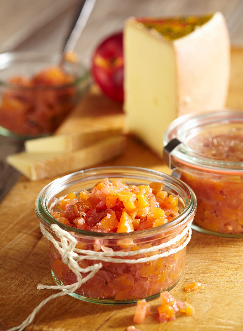 Jars of nectarine and apple chutney served with hard cheese