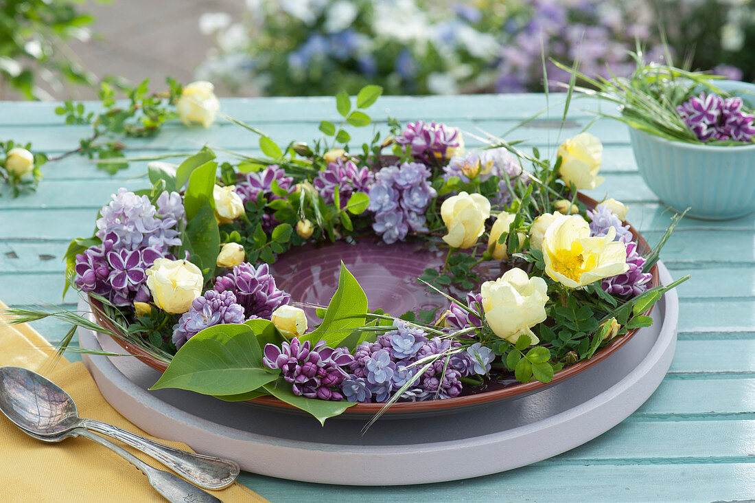 Wreath of lilac and yellow roses as a table decoration