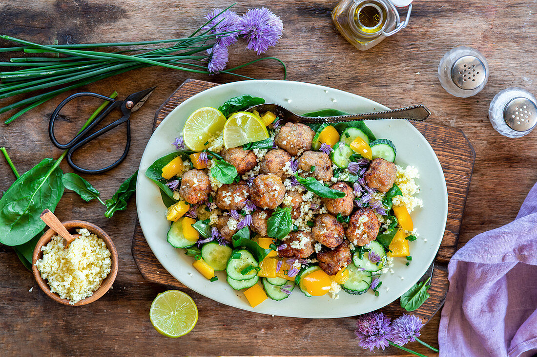 Meatballs and colourful vegetables on couscous