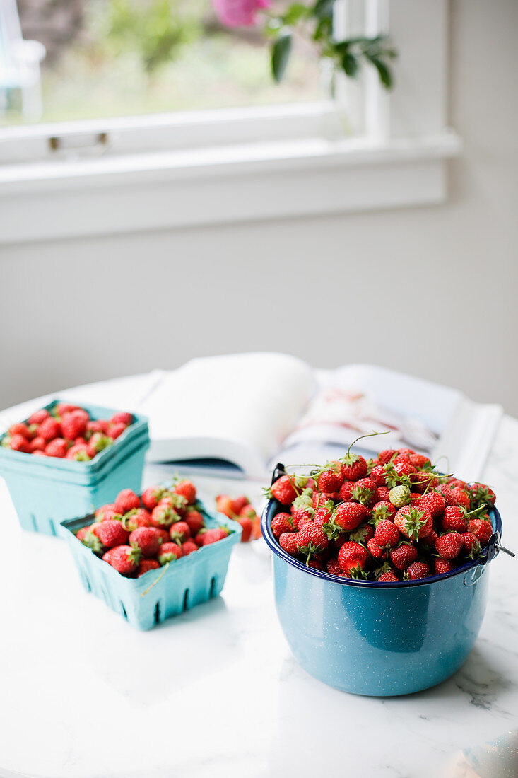 Frisch geerntete Erdbeeren in Schälchen auf Küchentisch