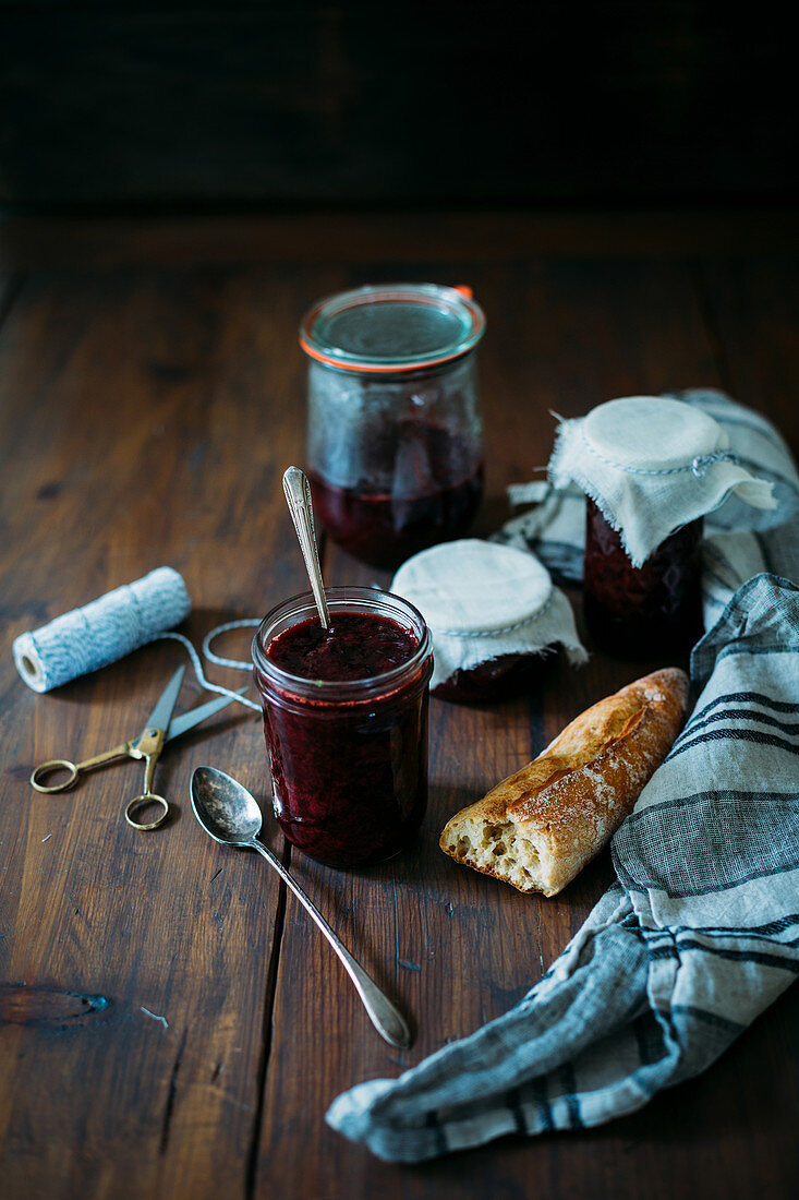 Jars of homemade strawberry jam on a rustic wooden table