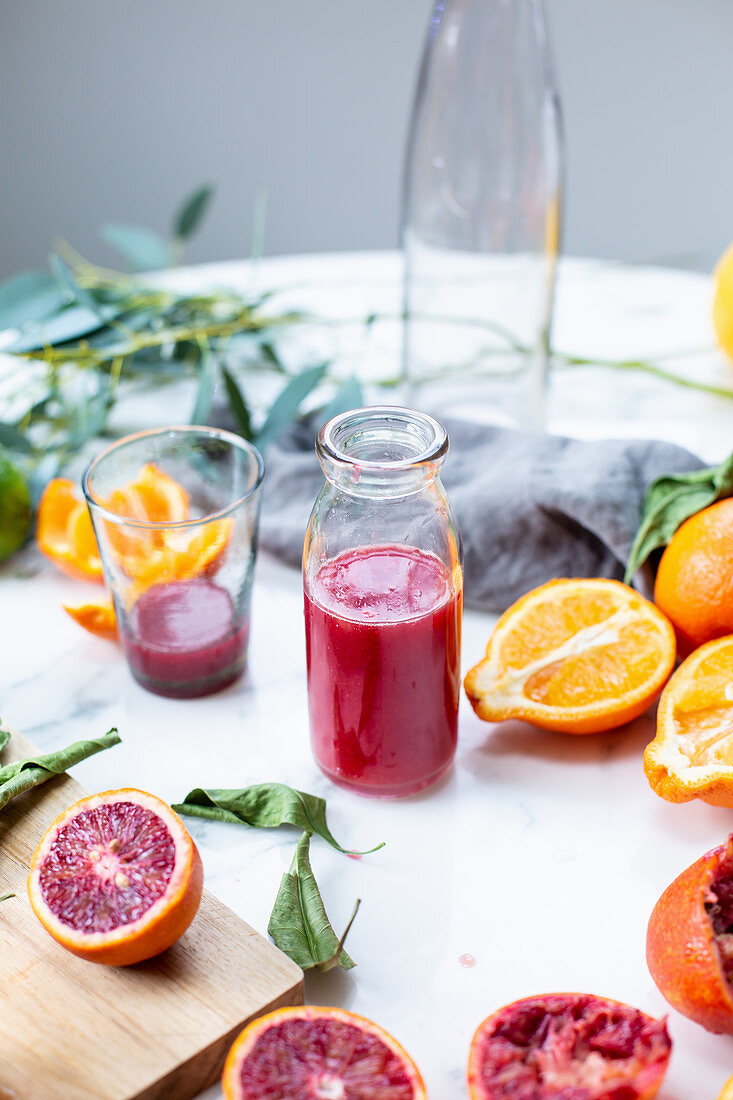 Freshly pressed blood orange juice in a glass and in a bottle