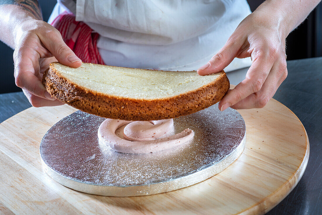 Preparing a wedding cake with an almond cake base layer, raspberry buttercream, and raspberry filling