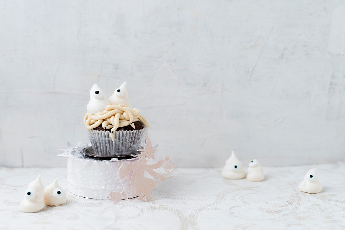 Halloweengeister aus Baiser auf Cupcake mit Würmern