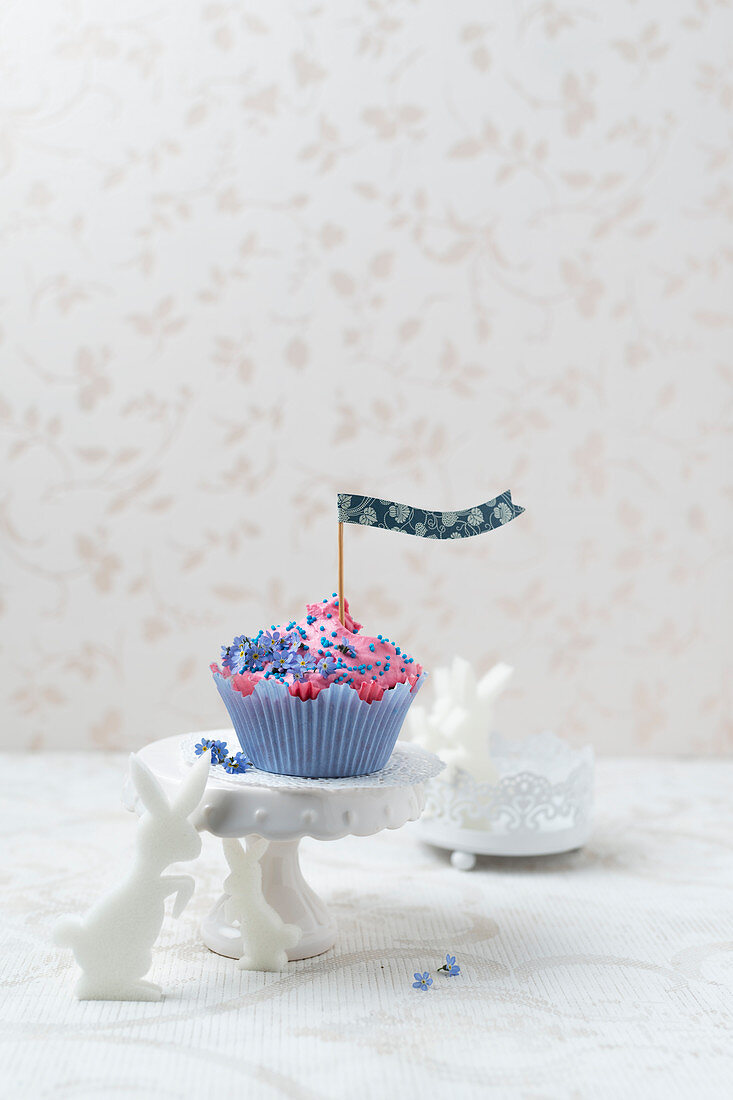 A cupcake with raspberry cream, forget-me-nots and rabbits (Easter)