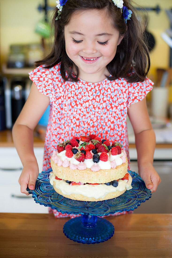 Little girl with a berry cake