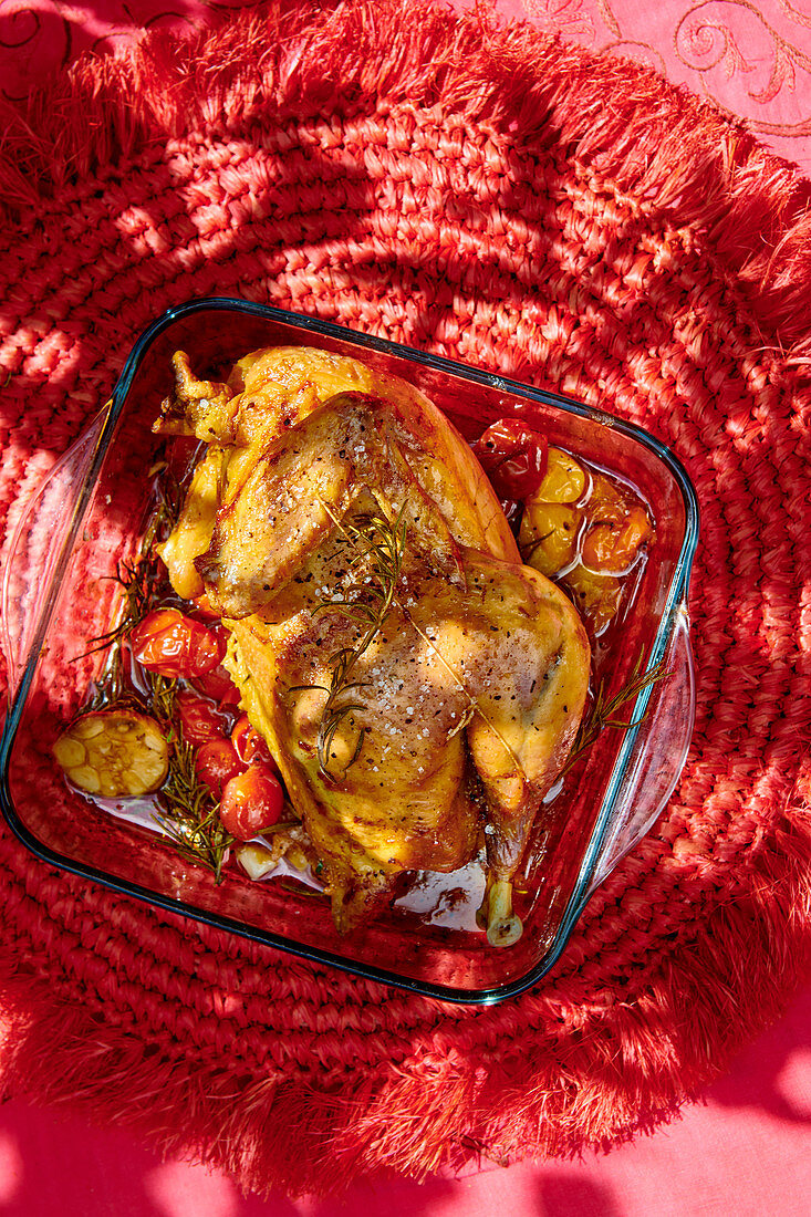 Half roast chicken with tomatoes and garlic