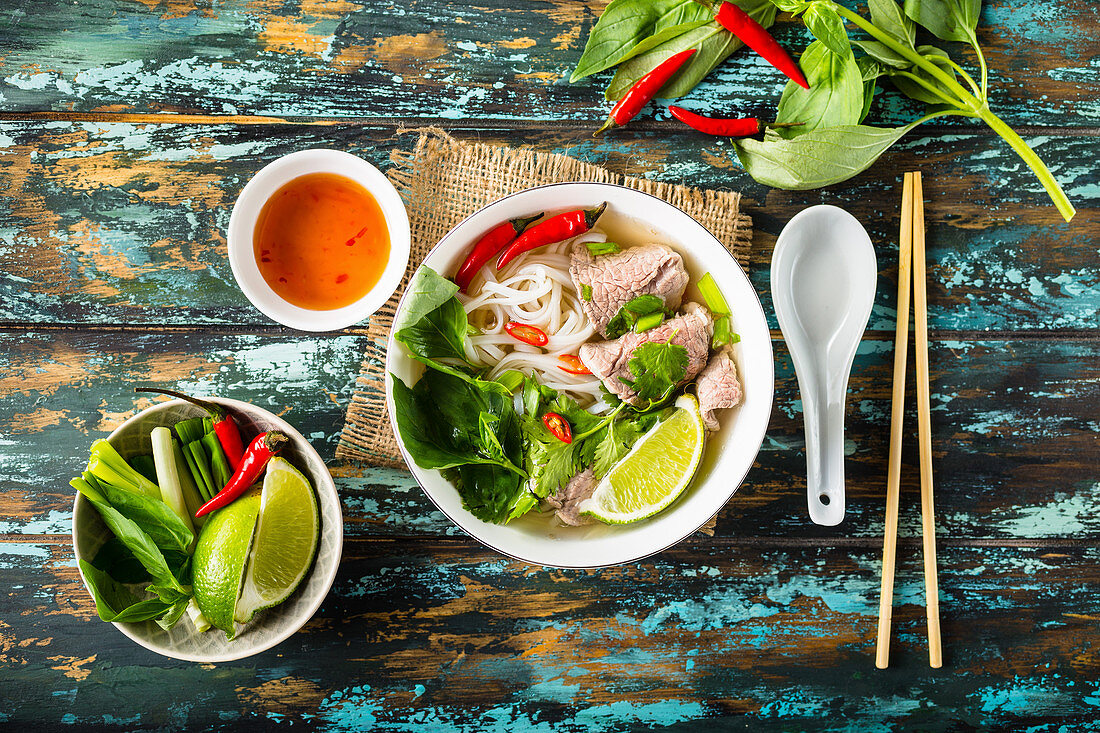 Traditional Vietnamese soup Pho bo with herbs, meat, rice noodles, broth