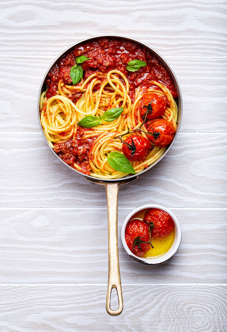 Spaghetti alla bolognese in der Pfanne mit Ofentomaten und Basilikum