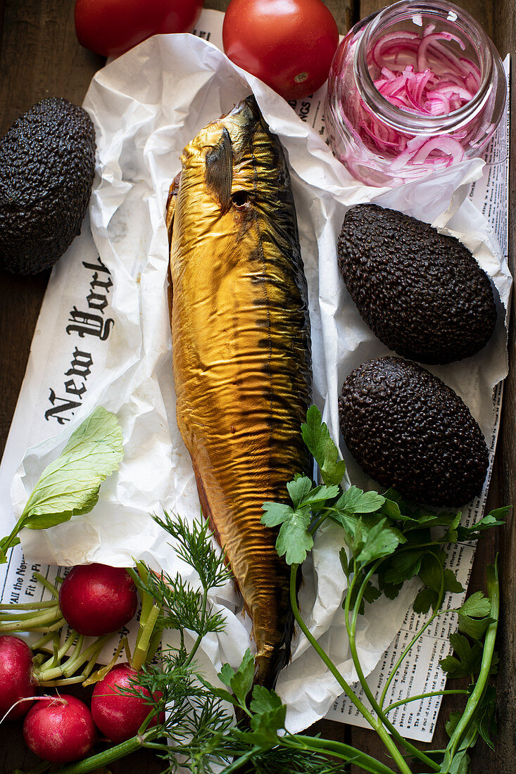 Still life with smoked trout, avocados, radishes, tomatoes and pickled onions