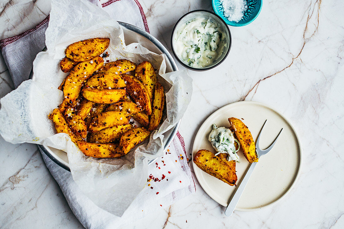 Spicy potato wedges from a pressure cooker served with a dip